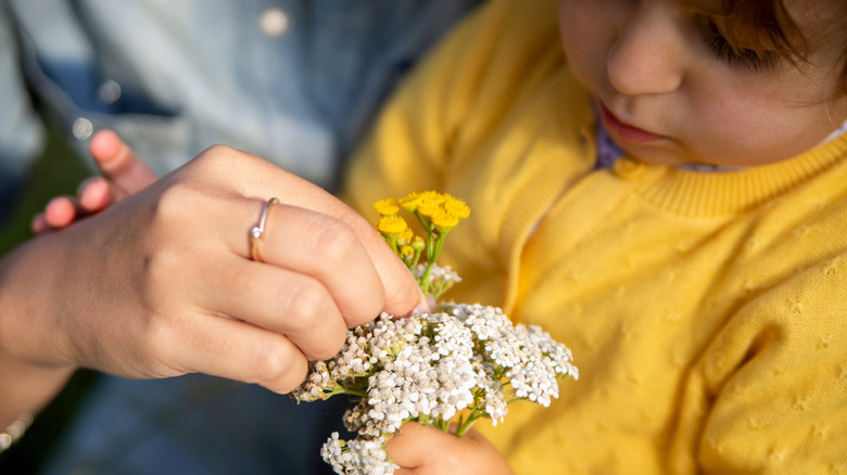 mother and child holding yarrow