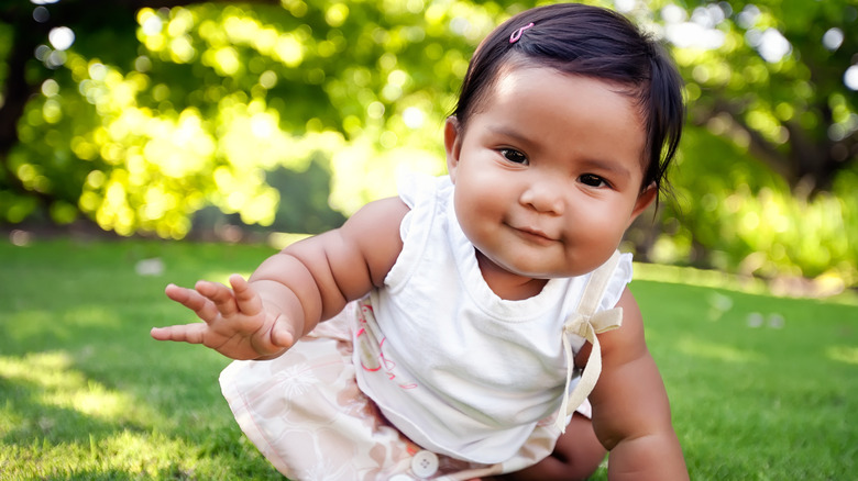 Baby crawling in grass