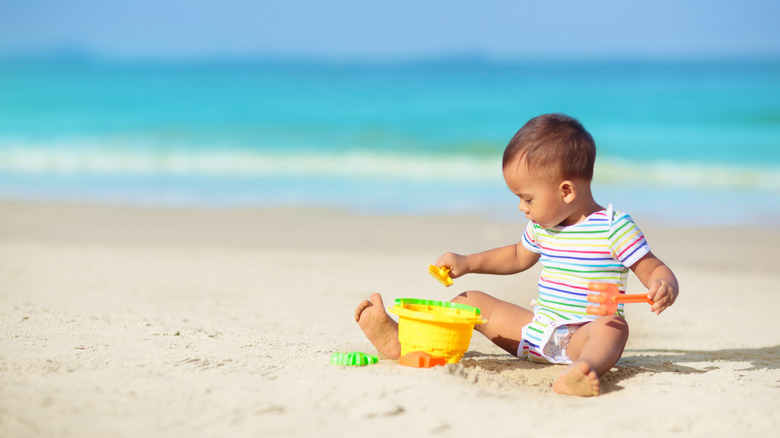 baby boy playing on the beach