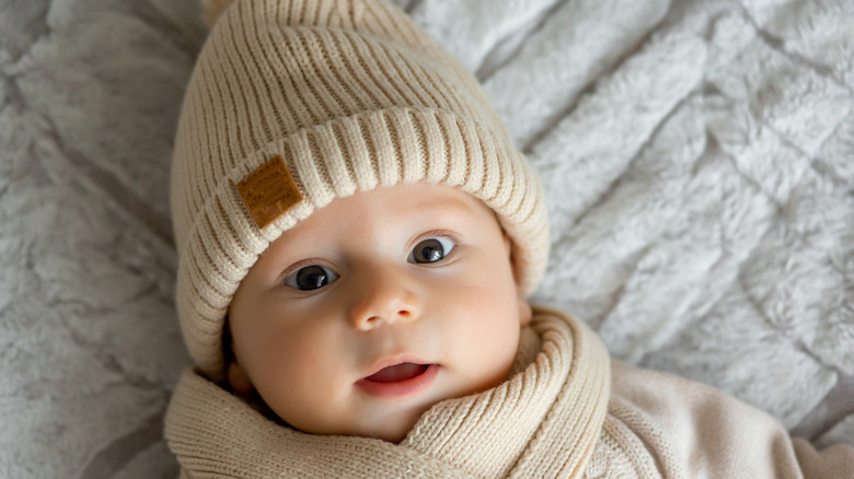 Baby boy in beige knit hat and scarf