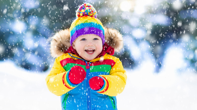 Baby in the snow in colorful outfit