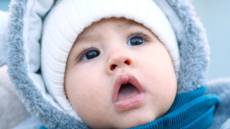 Baby boy in white hat with fur hood