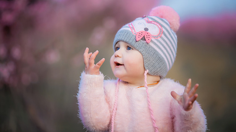 Baby girl in pink fuzzy sweater and snow hat