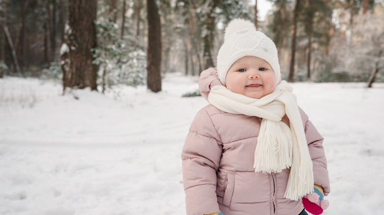 Baby girl in pink coat with hat and scarf