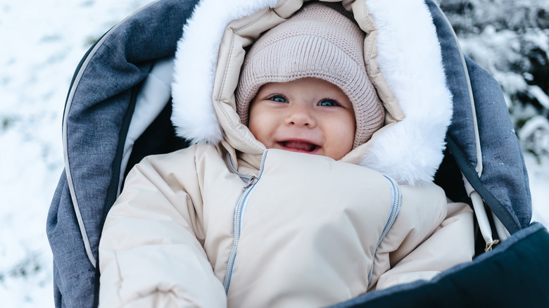 Baby girl bundled up in stroller in snow