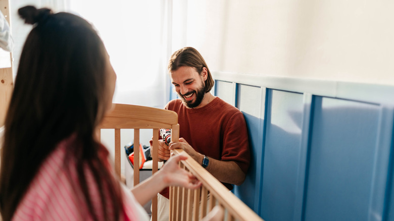Friends help assemble a baby crib
