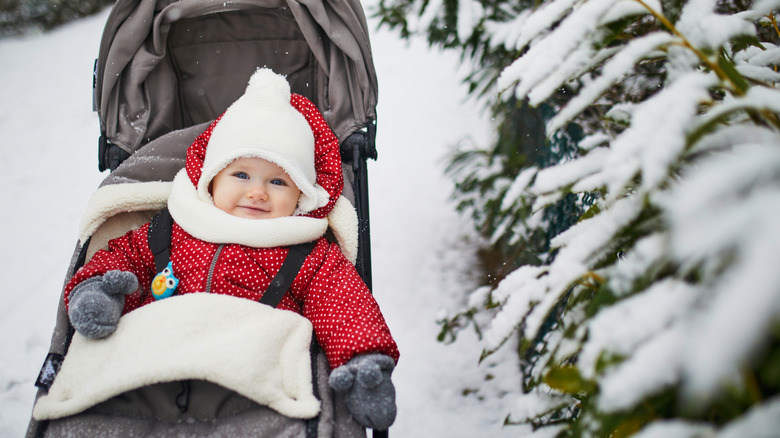 Baby girl in a stroller in the snow