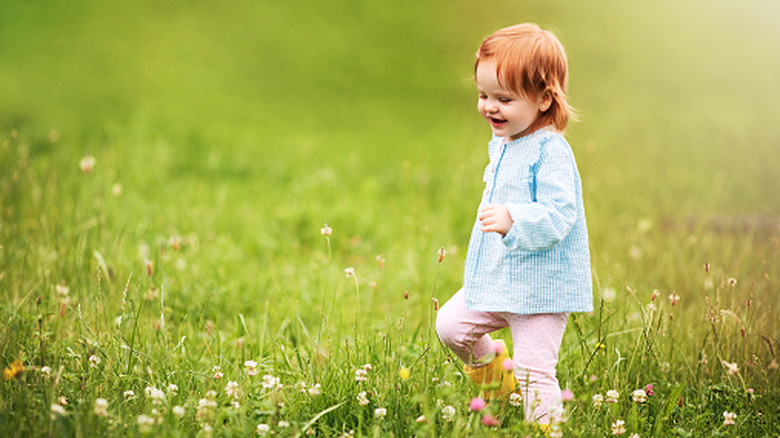 child laughing in the grass