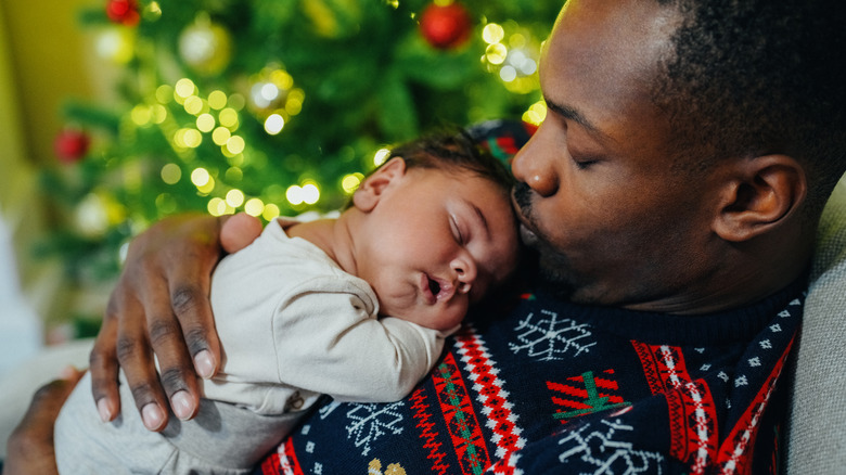 sweet sleeping baby boy at Christmas on top of father