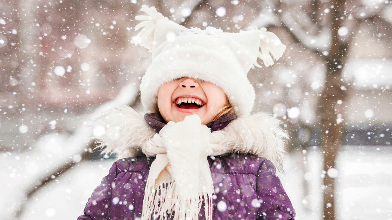 little girl laughing in the snow
