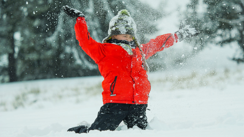 little boy playing in the snow