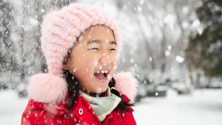 little girl laughing in the snow