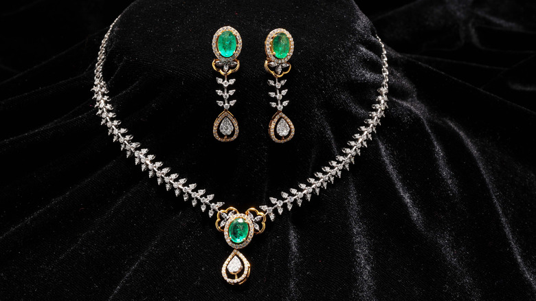 emerald necklace and earrings on velvet black cloth