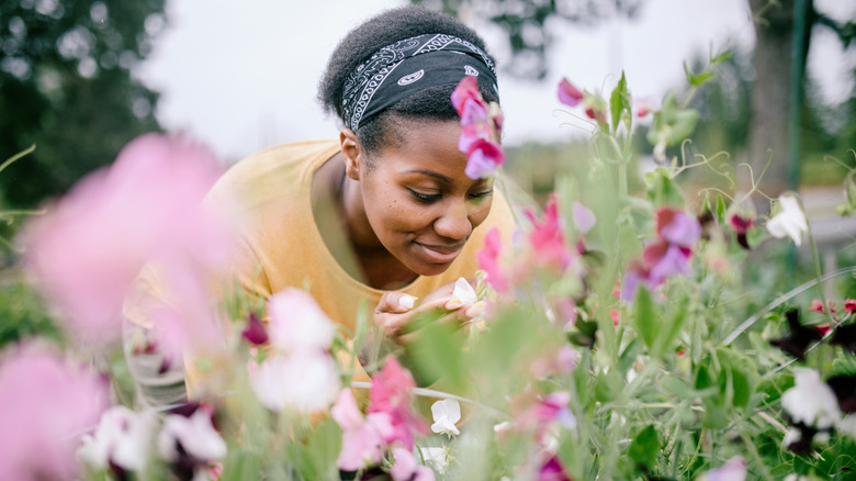Woman smelling pink flowers outside