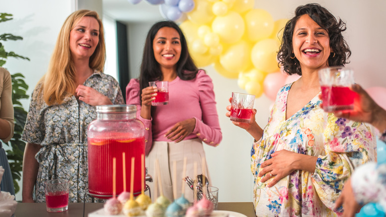 Women in colorful outfits celebrating baby shower