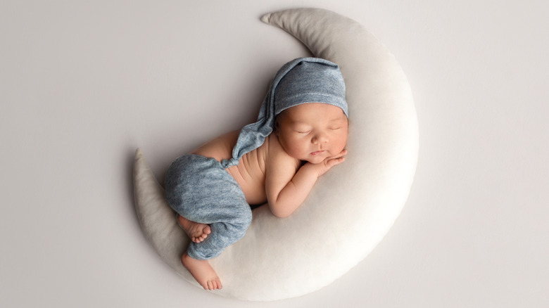baby snuggling with a plush moon
