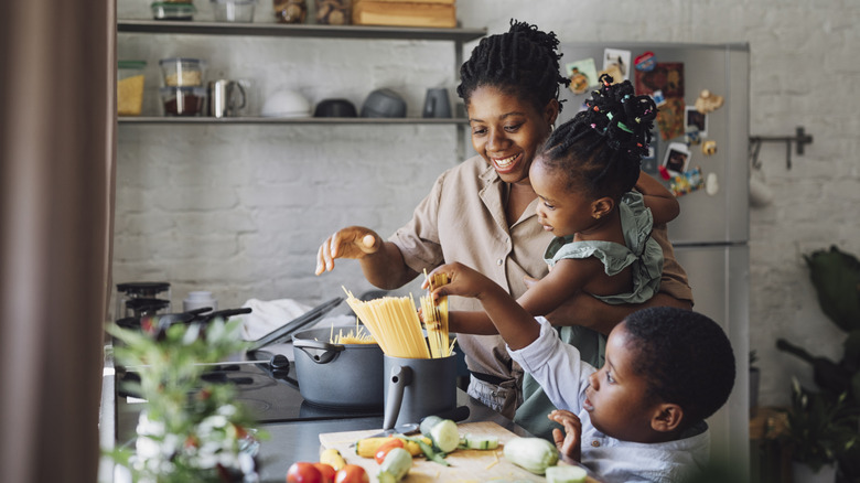 Mom cooking dinner with two kids
