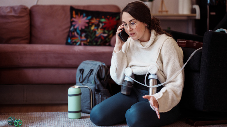 woman using breast pump while talking on the phone