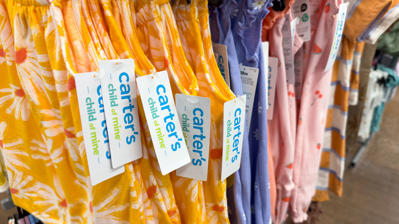 Carter's Child of Mine brand clothing hanging on a rack at a store with the tags facing the camera
