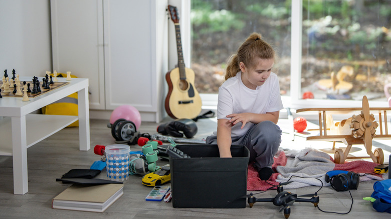 child organizing a messy playroom