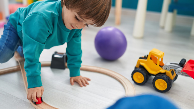 child playing with hard toys on vinyl floor