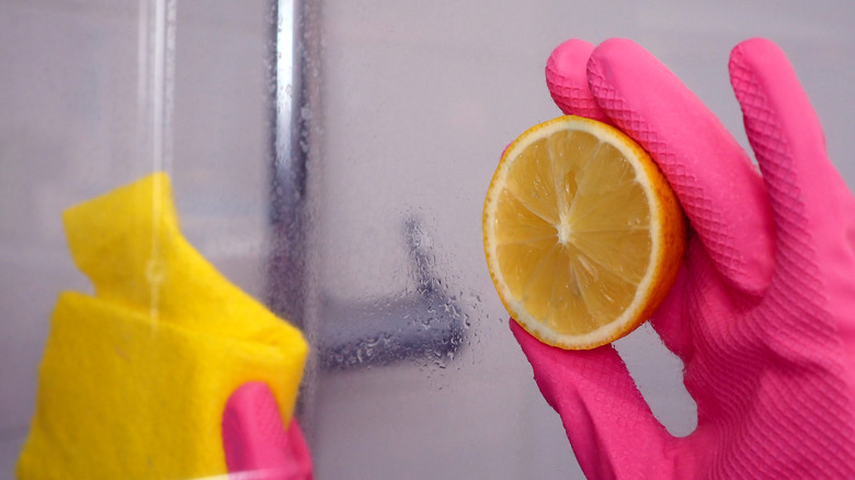 Person with pink rubber gloves cleaning with lemon juice
