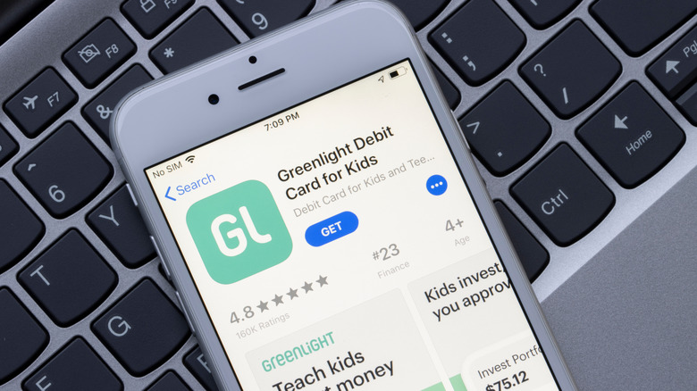 Phone displaying the Greenlight mobile app on top of a keyboard