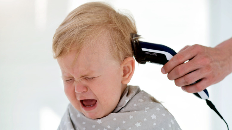 Crying baby getting hair cut