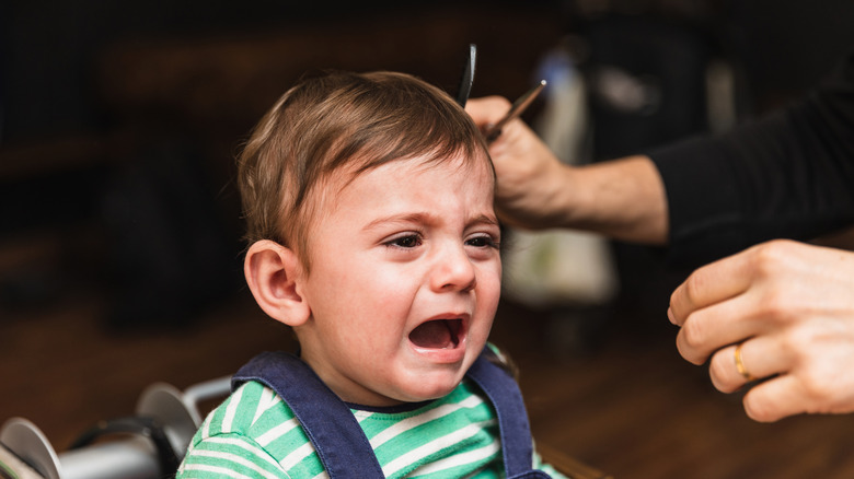 Toddler boy upset by haircut