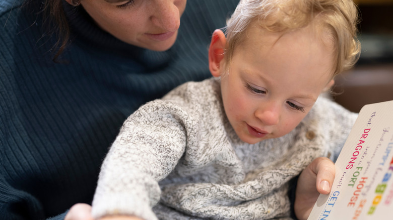 Child looking at book with parent