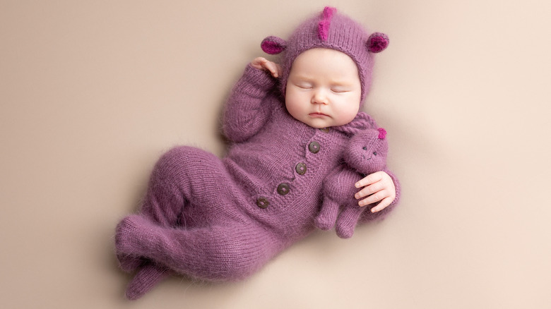 baby sleeping in a dragon costume