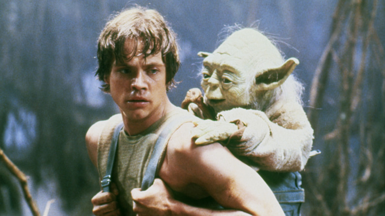 Mark Hamill as Luke Skywalker holding Yoda