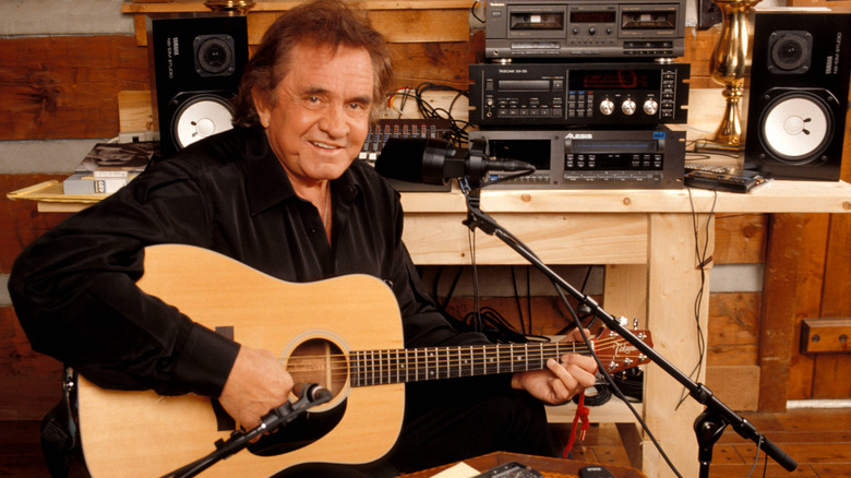 Johnny Cash with guitar and recording equipment