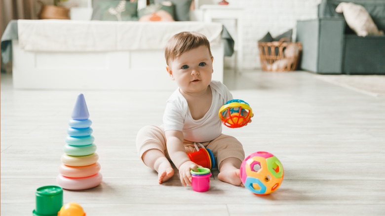 Baby girl playing with colorful toys