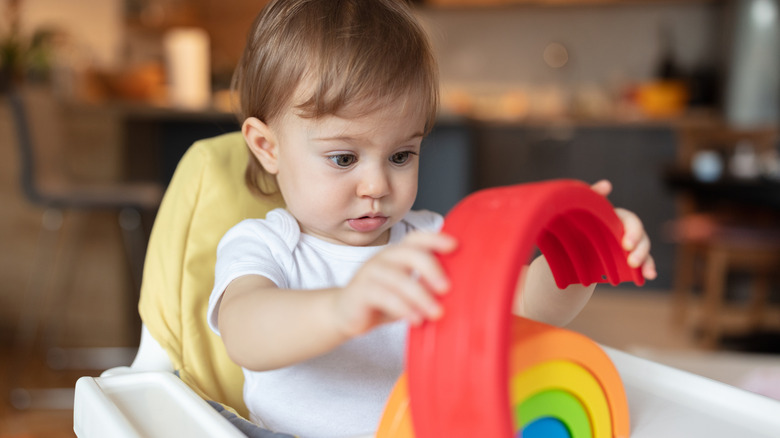 Baby playing with a rainbow toy