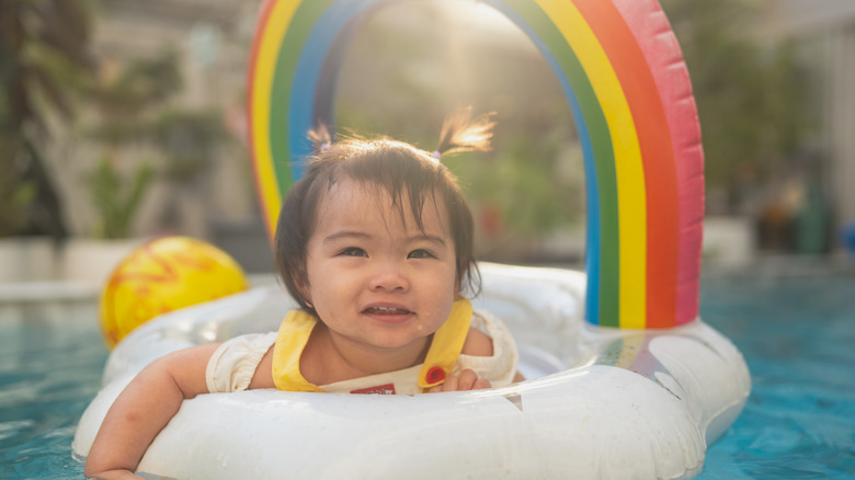 Baby in a rainbow pool float