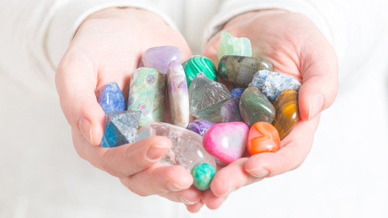 two hands holding birthstones