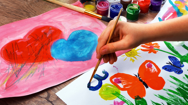 child doing a painting of flowers and butterfly