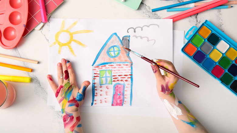 child painting a house