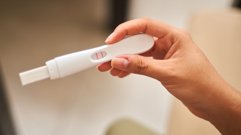 Hand holding an at-home pregnancy test
