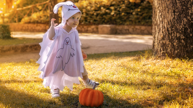 Little kid dressed as a ghost for Halloween