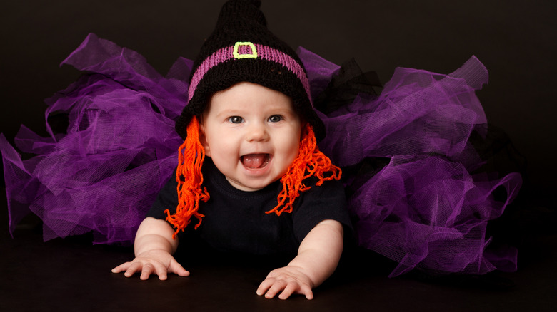 Baby girl in black costume with purple tulle