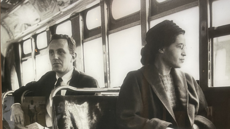 Rosa Parks seated on a bus looking out the window