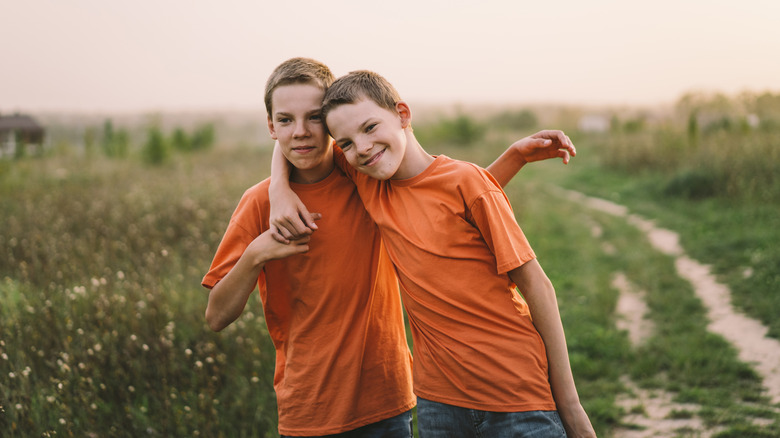 Twin boys outdoors in orange T-shirts