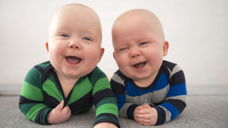 Twin babies in striped shirts laughing