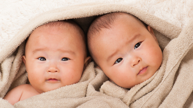 Twin Asian babies in towel