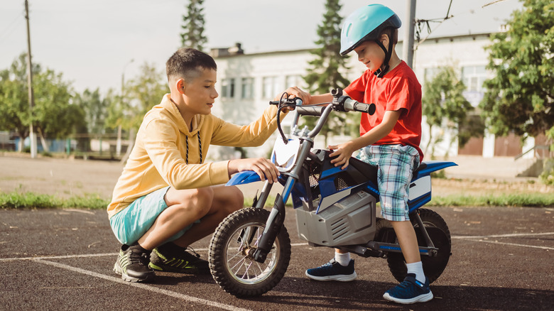 Older boy showing younger boy how to use an e-bike