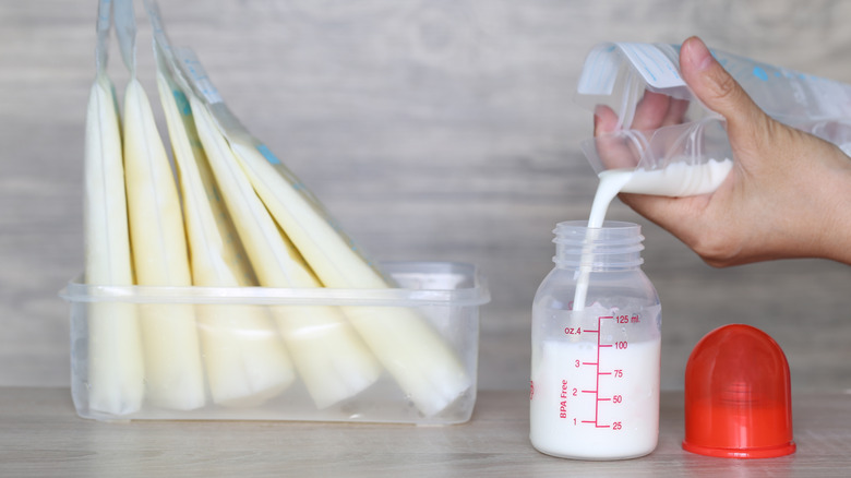breast milk in bags with person pouring contents from one bag into a bottle