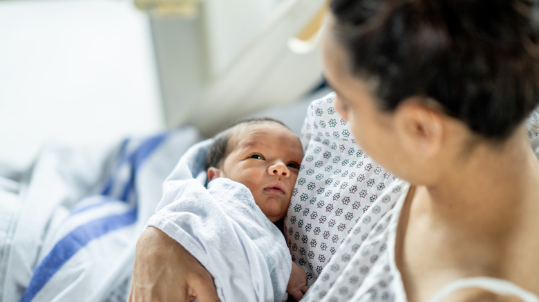 mother looking down at baby in a hospital bed