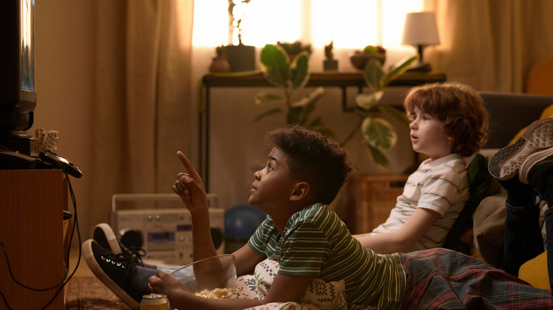 two kids watching tv in a retro living room